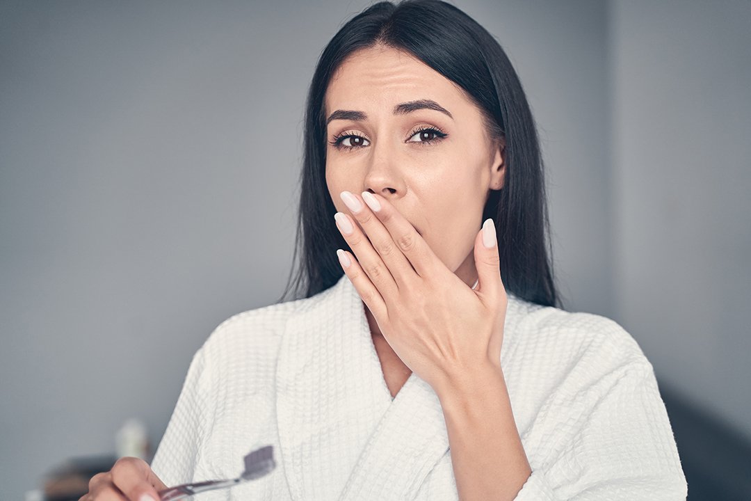 Stunned young Caucasian woman holding a toothbrush